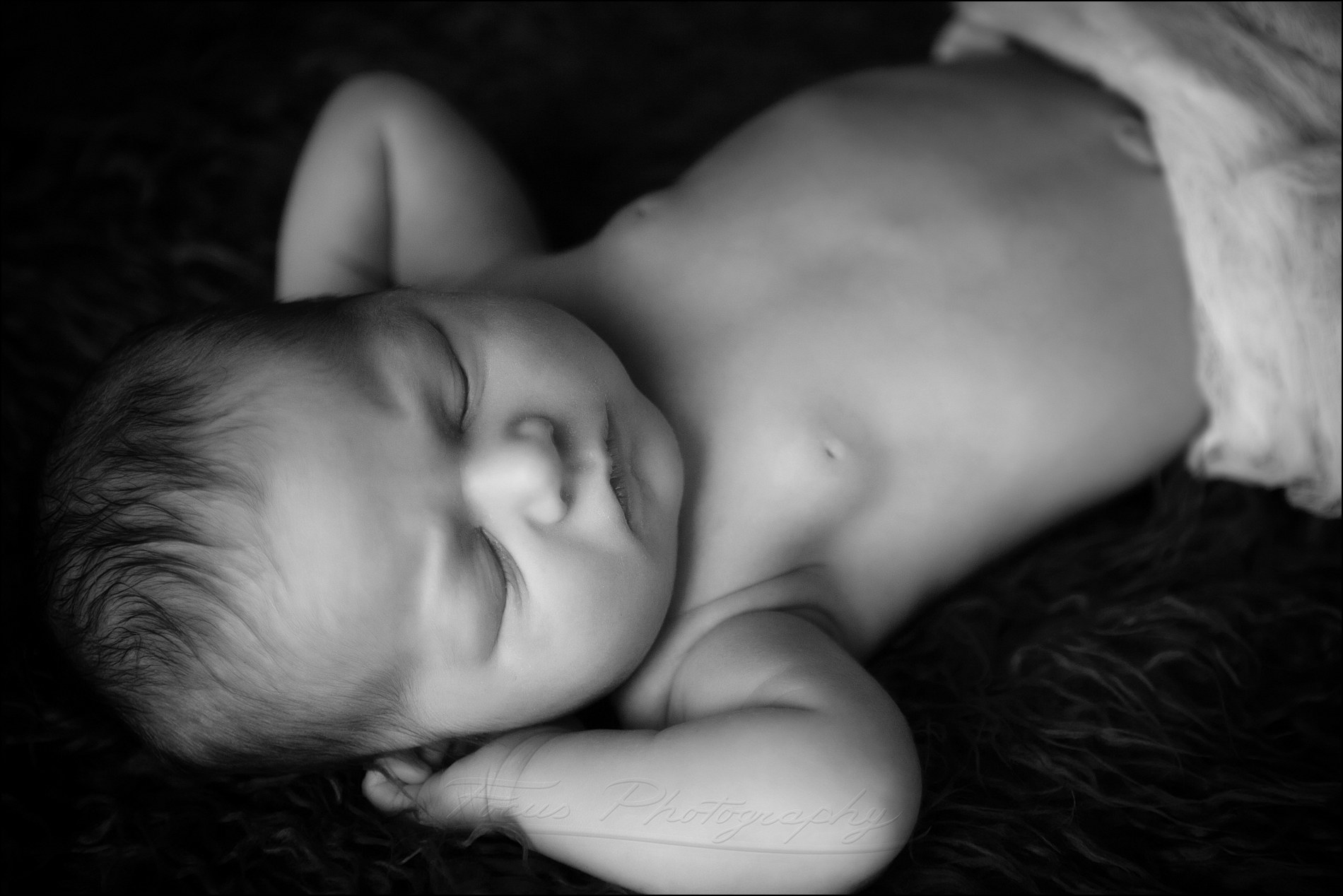 newborn baby in black and white image reclines and sleeps