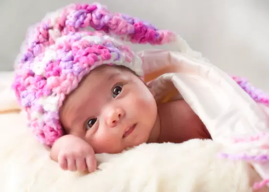 baby photos with pink hats and robes at newborn photography studio in maine
