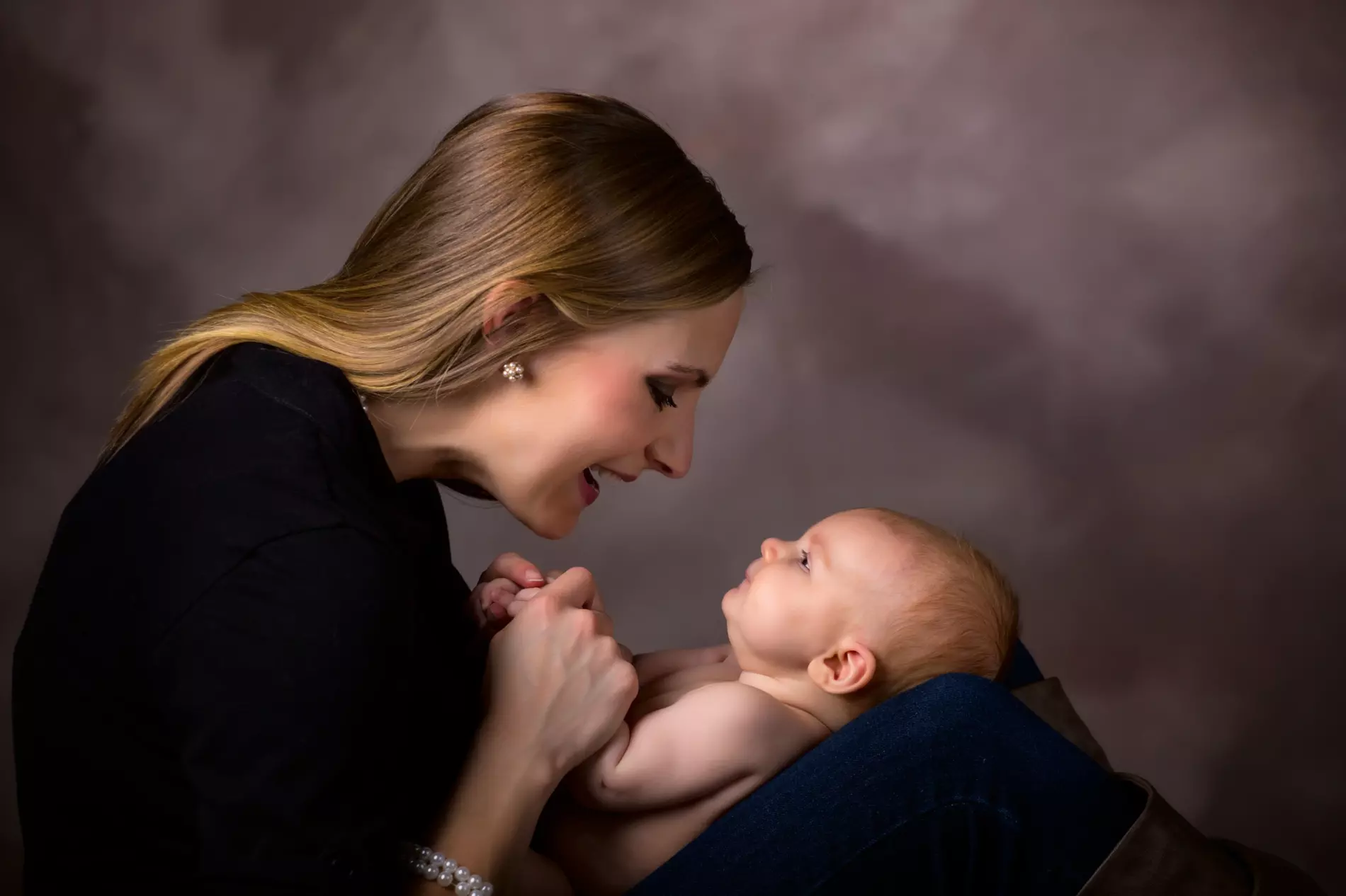 New mothers hold their babies close in newborn photography studio
