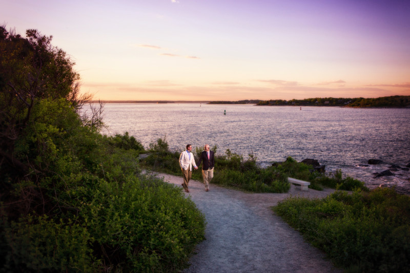 2 gay men walk hand in had for engagement pictures in maine