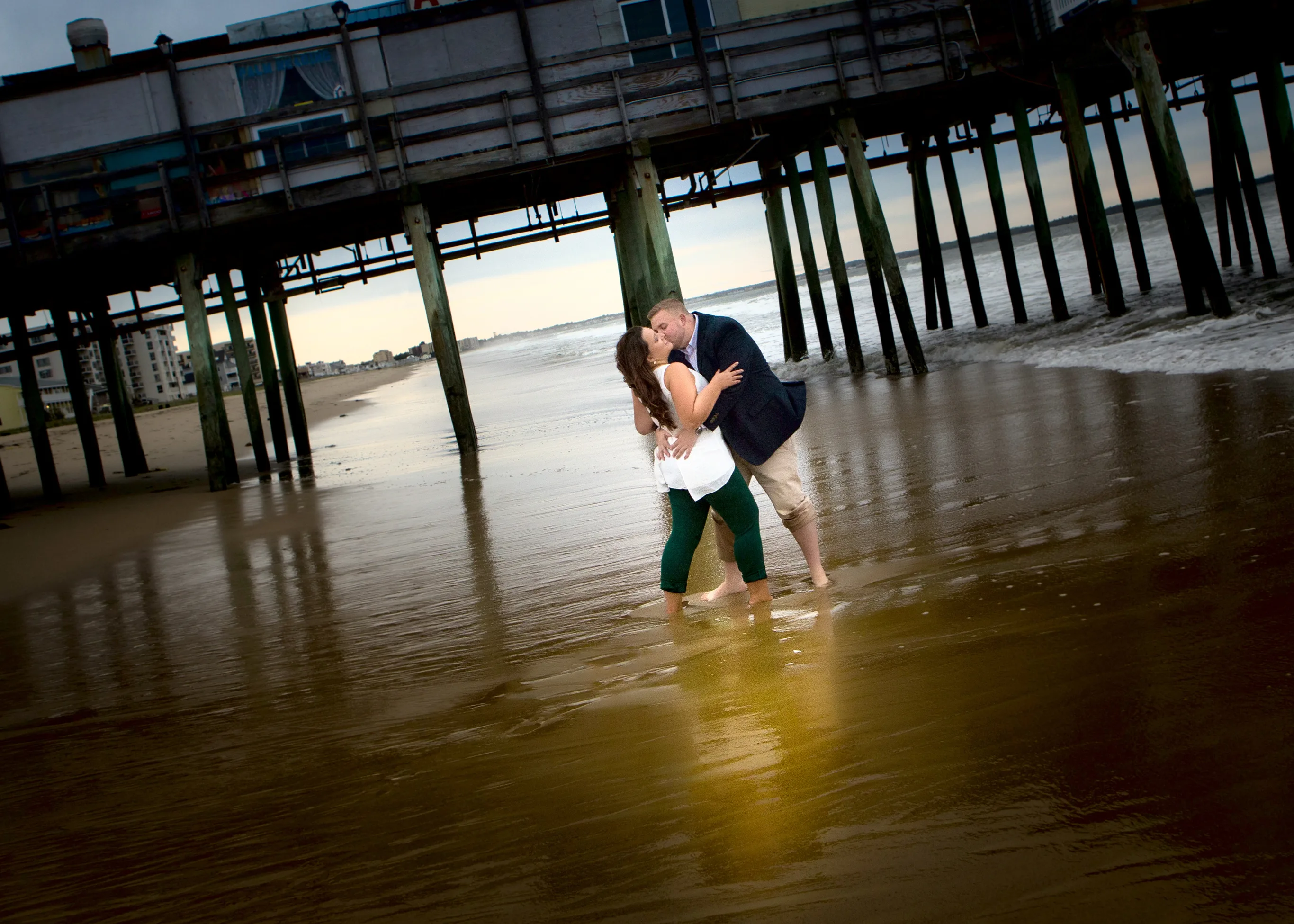 Engagment pictures of Brittney and Craig under the pier at Old Orchard Beach in Maine.  They were married at the Landing on Pine Point in Scarborough.