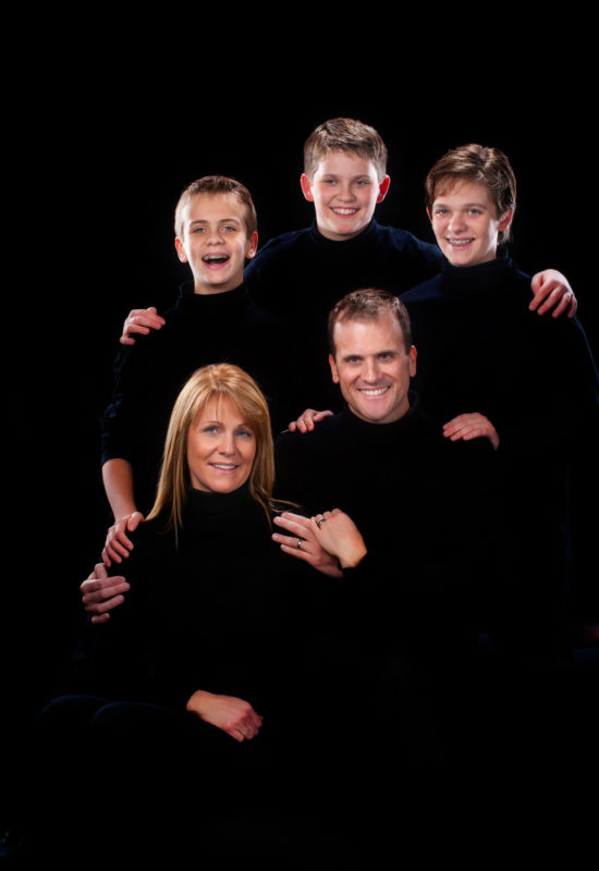 emotive low key portrait of family on black