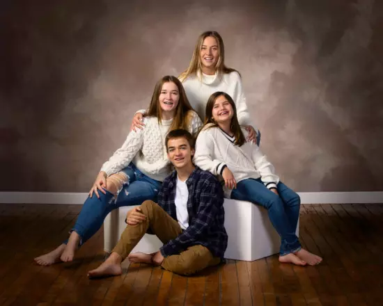 family portrait in maine photography studio with 4 siblings on brown background