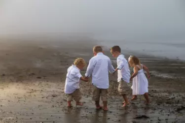 boys playing on beach in fog