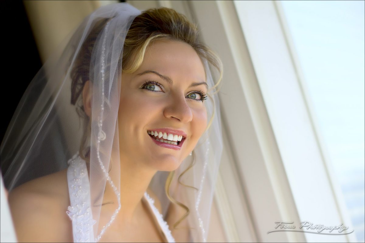 bride looks out window on wedding day