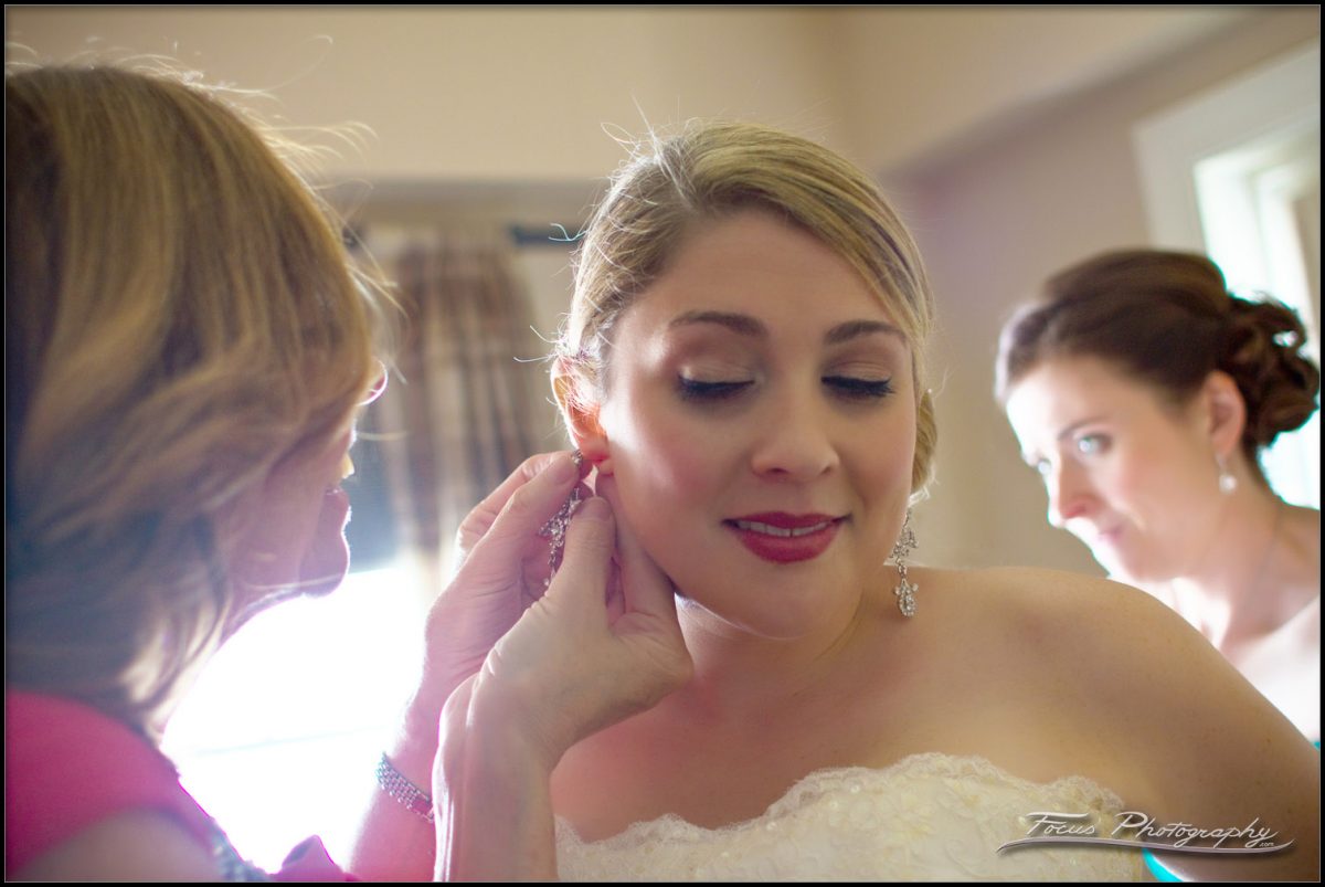 The bride's mother helps her put on her earings