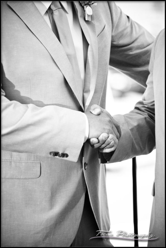 The best man shakes the groom's hand