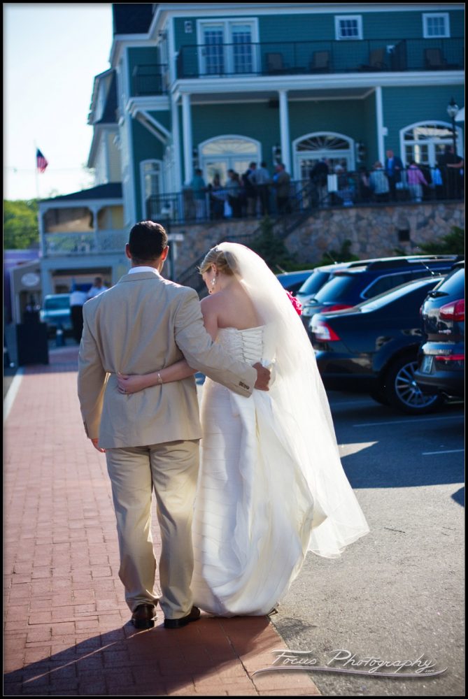 bride and groom walk down the sidewalk at York Beach, Maine
