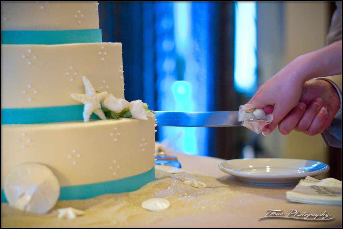 bride and groom's hands on the knife during wedding cake cutting