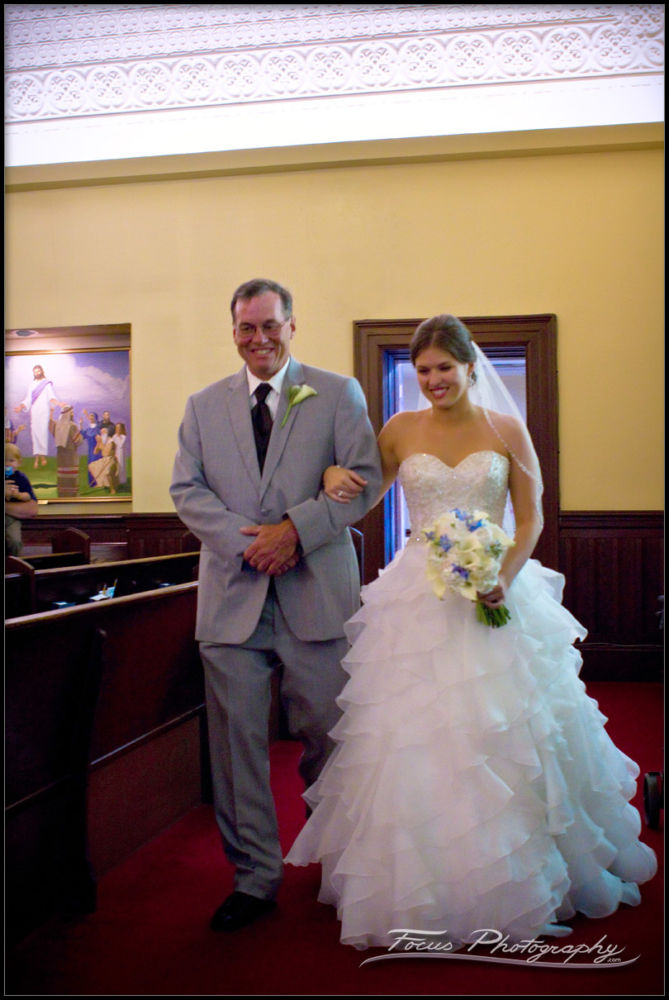 the bride and her father enter the back of the church