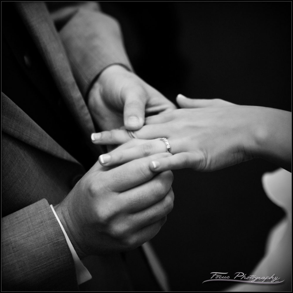 the groom puts the wedding ring on the bride's finger