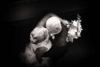 Bride and groom kiss in black and white wedding portrait.
