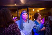 Man on dance floor with tie around his head.