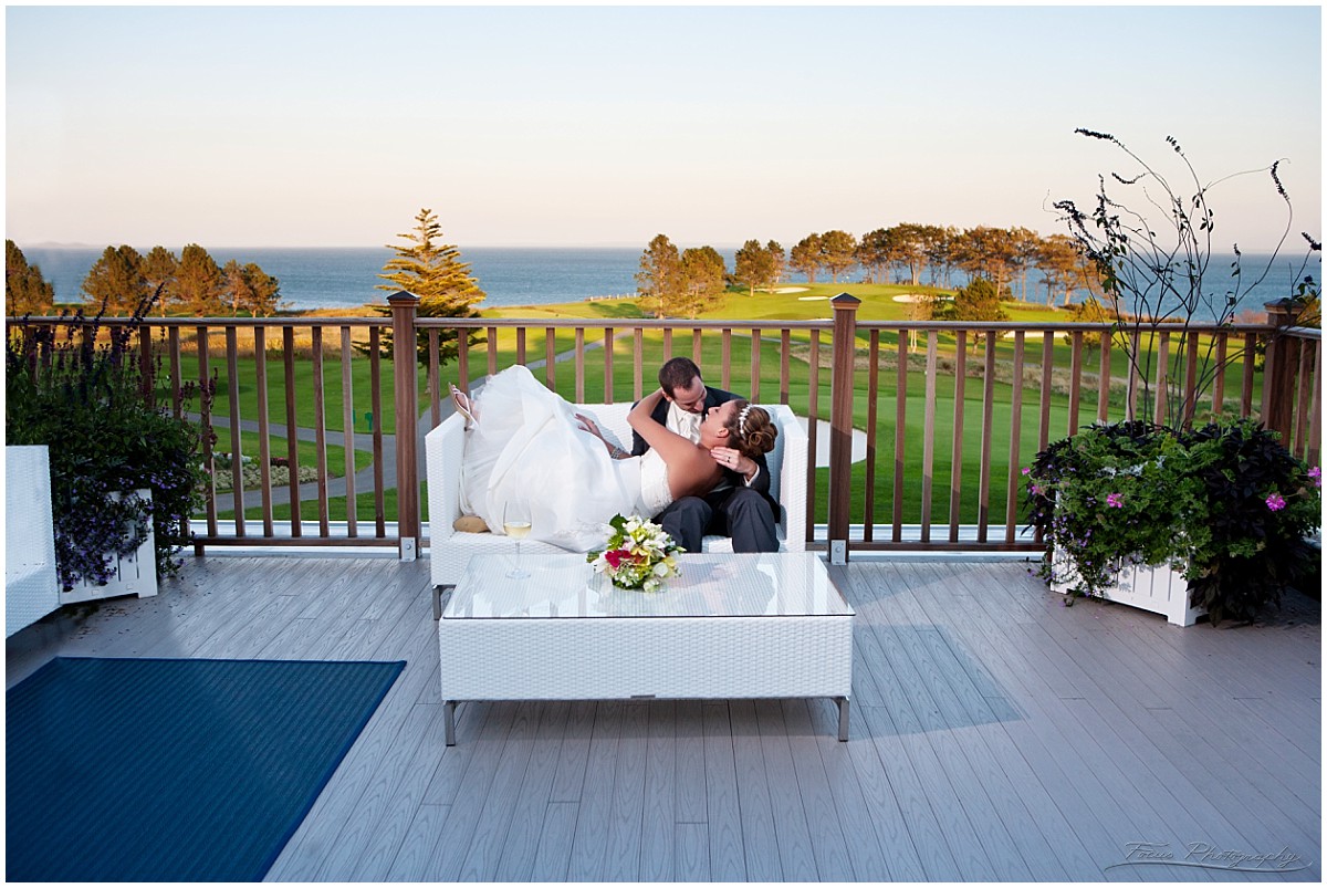 couple kiss on back porch at Samoset resort wedding in Maine