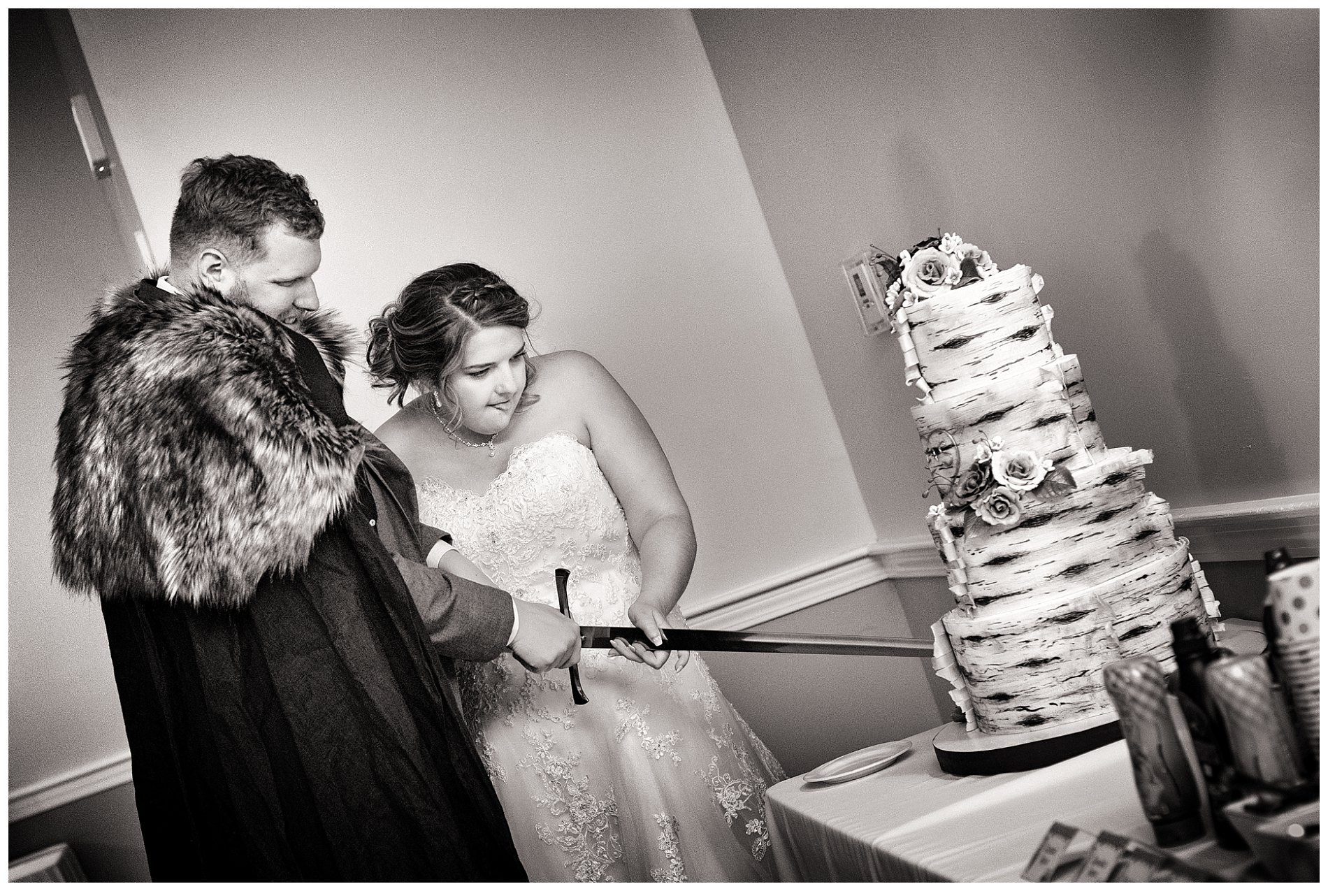 bride and groom cut the wedding cake with sword