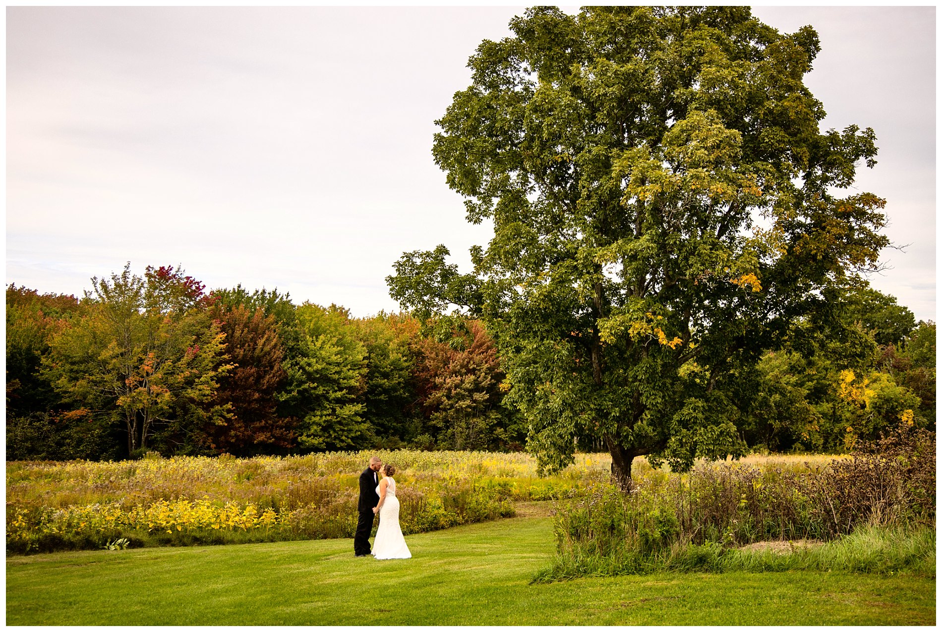 fall colors are the background for wedding pictures in wells, me