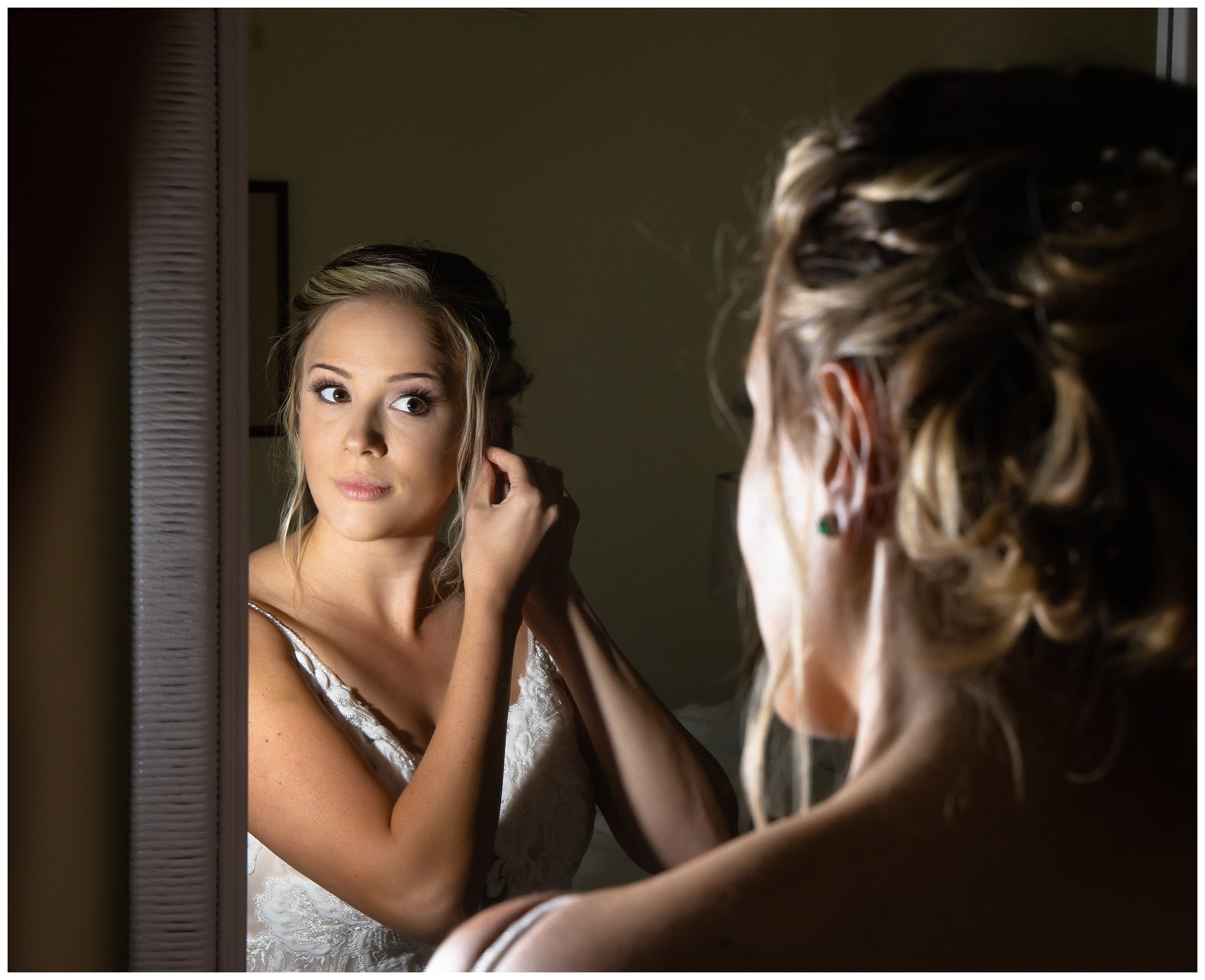 bride looking into mirror at wedding