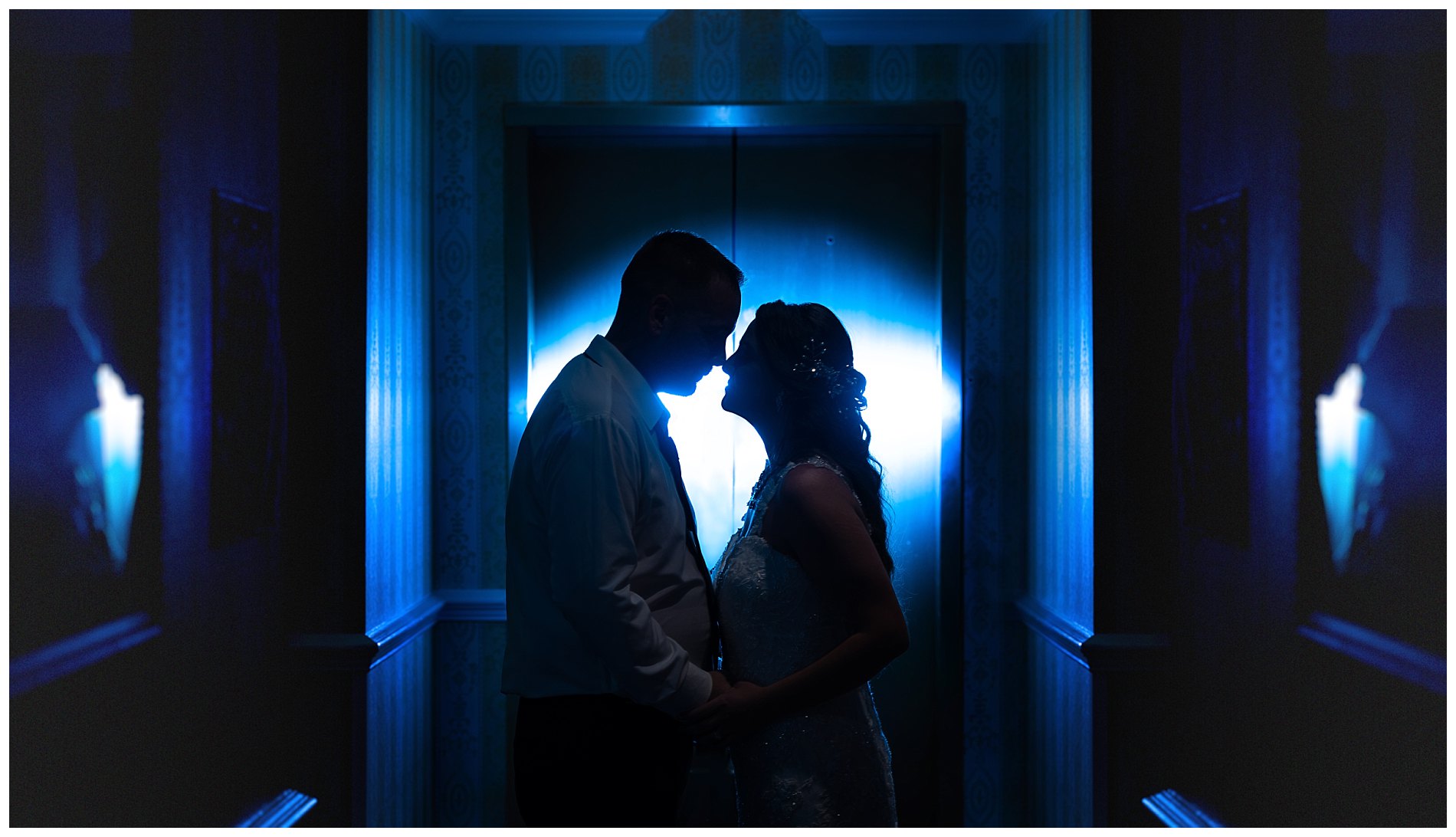 bride and groom in hallway outside elevator.