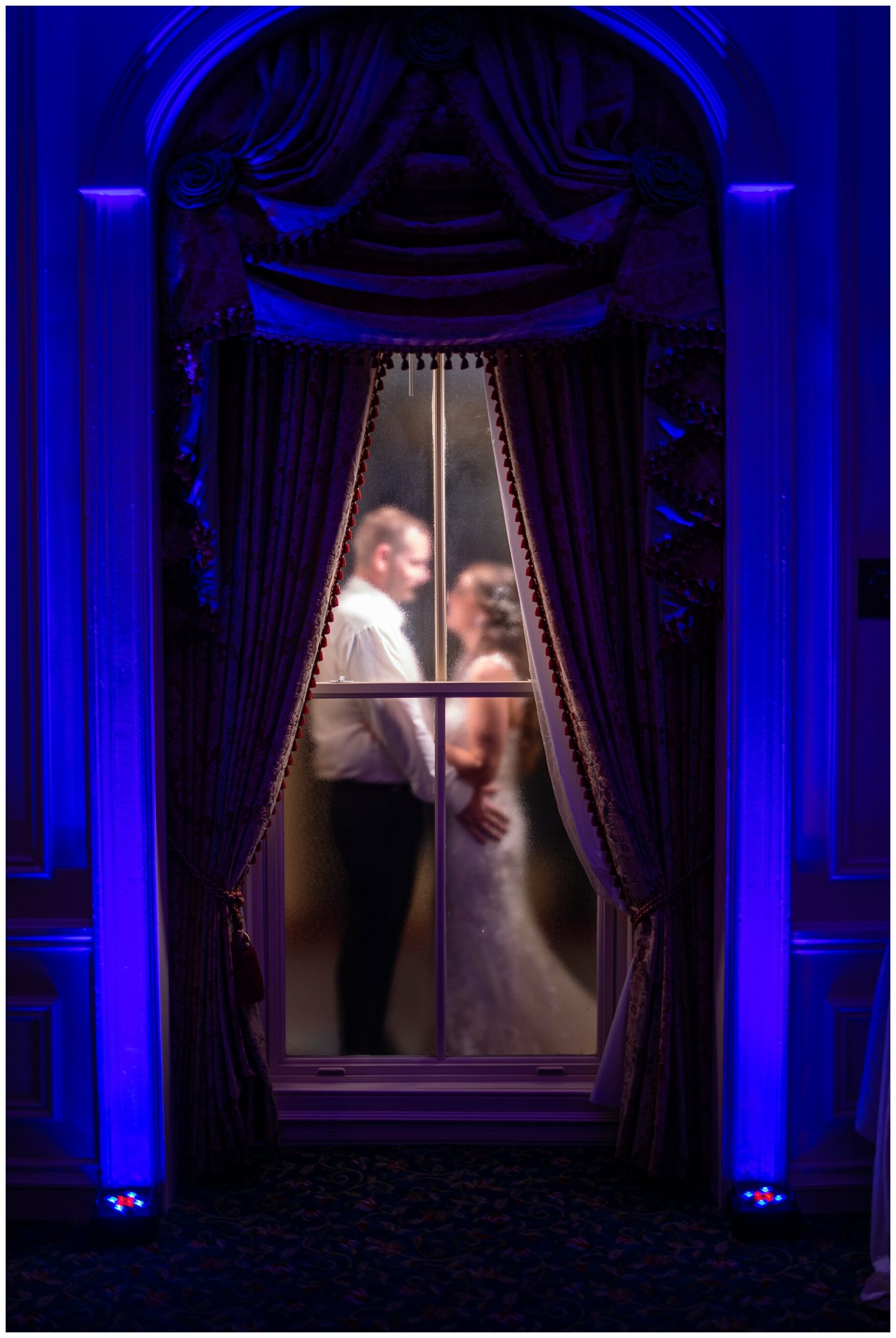 windows in the Grand Ballroom at the Wentworth, with the couple behind them.