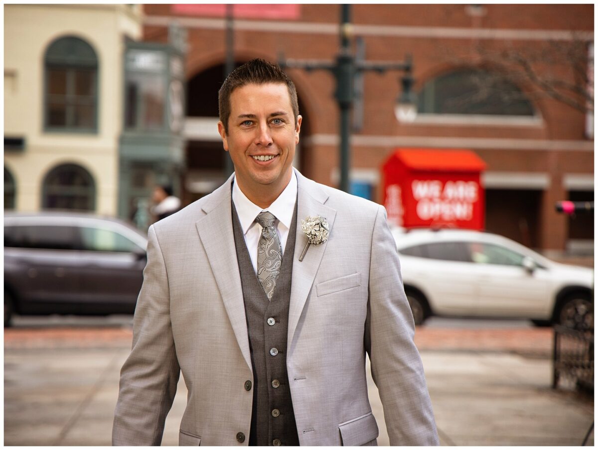 Groom in portland downtown with museum behind him.