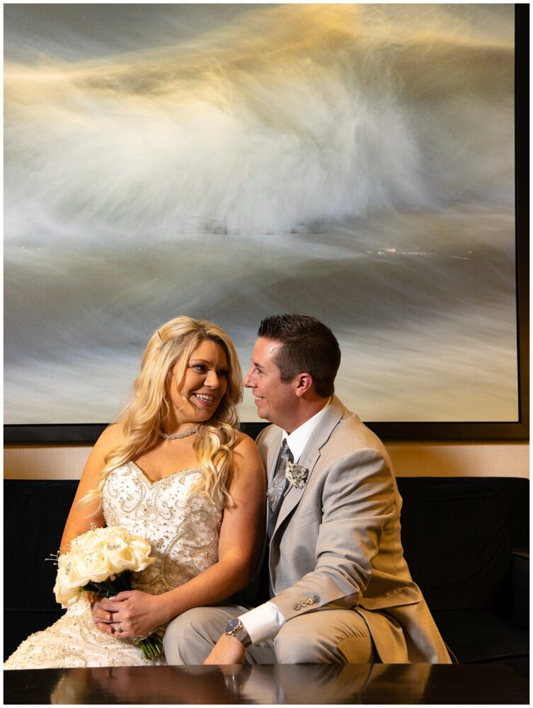 Wedding couple in front of wave painting in Westin hotel in portland Maine.