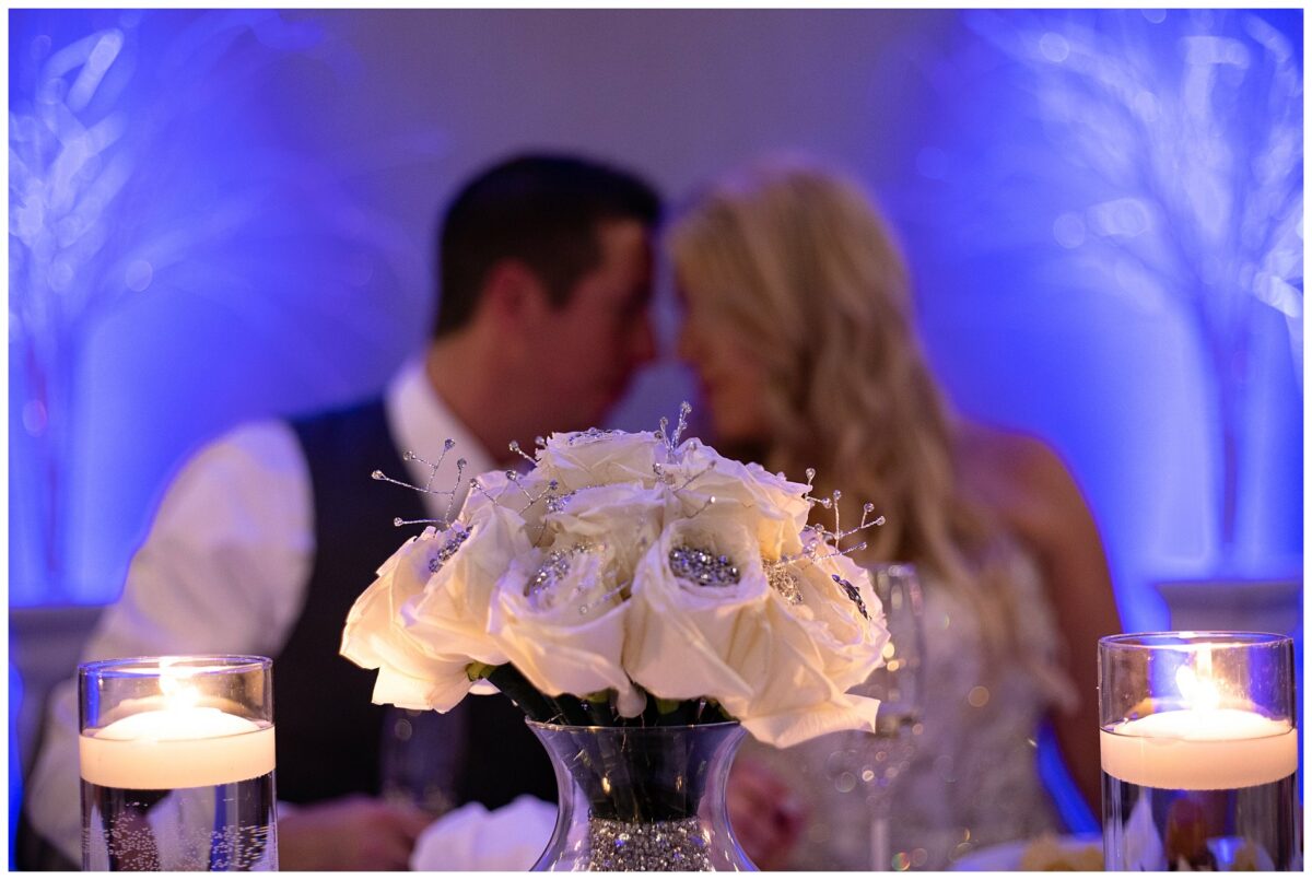 Wedding couple looks towards each other with flowers in foreground