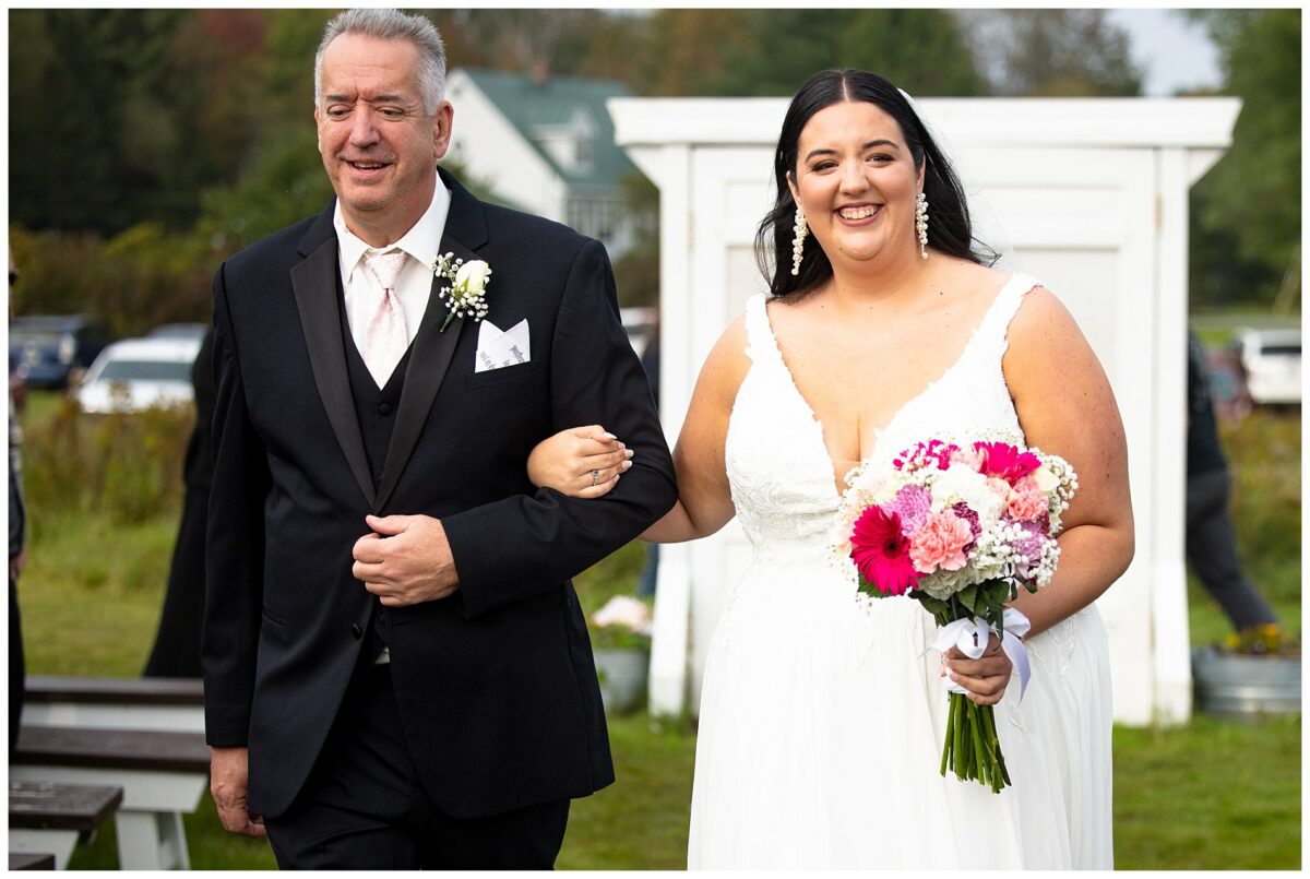 the bride and her dad walk down the aisle