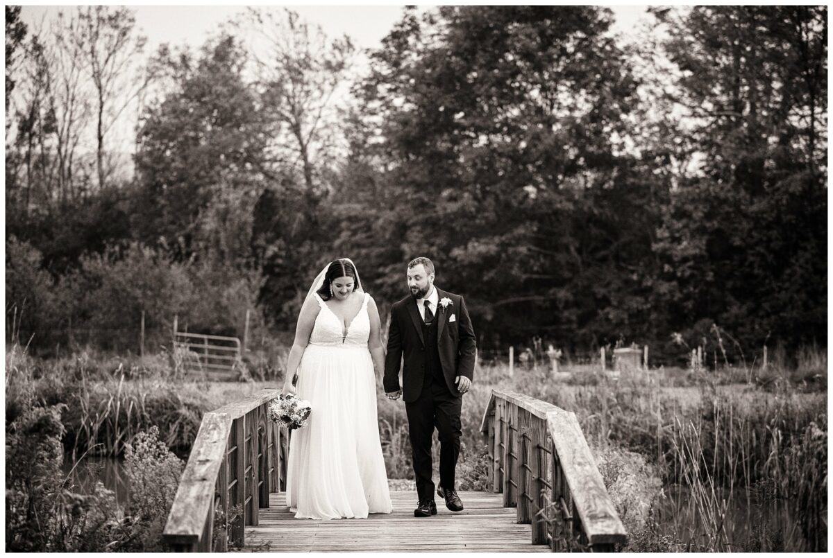 bride and groom walk over bridge