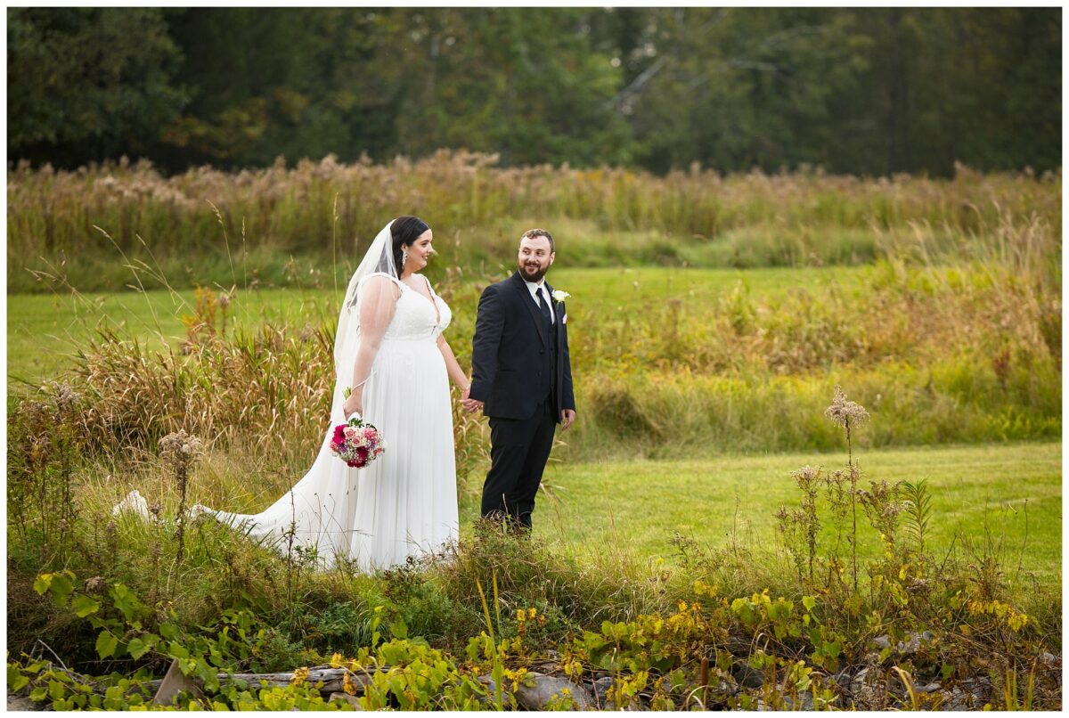 wedding couple walks across field