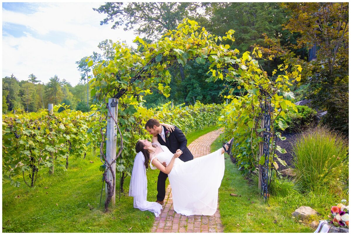 wedding couple under archway of grape vines