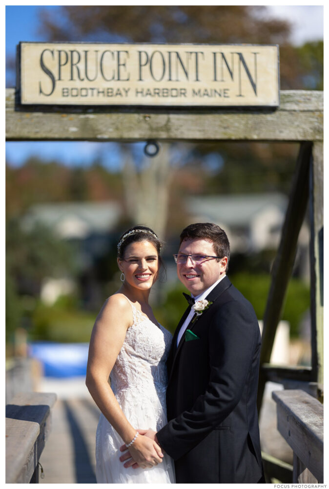 wedding couple under spruce point inn sign in boothbay harbor