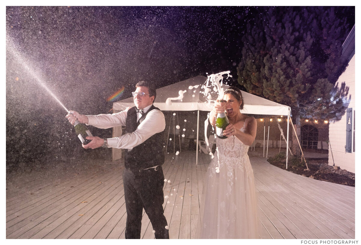 groom opens a bottle of champagne