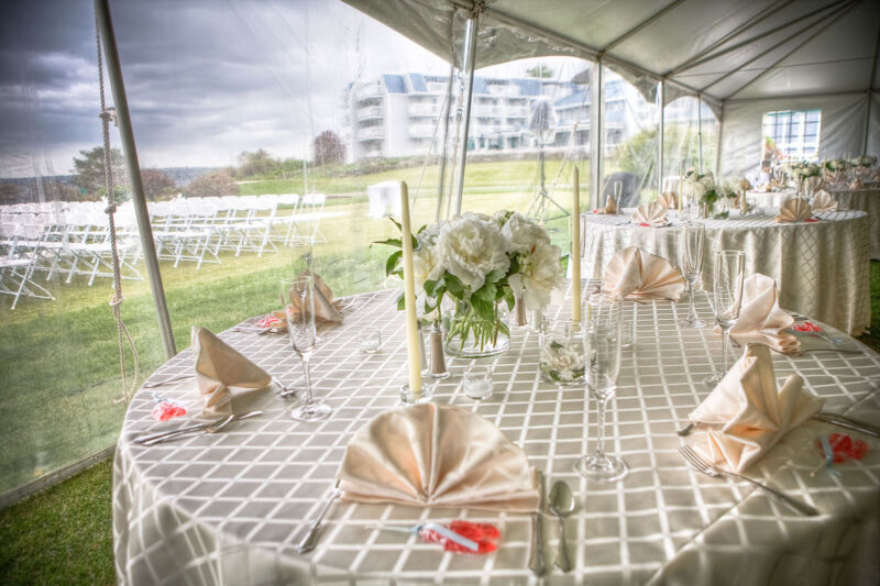 Wedding reception setup at Samoset Resort with white flowers Elegant wedding reception setup at Samoset Resort in Rockport Maine featuring beautifully set tables with white flowers and folded napkins by Samoset Photographer.