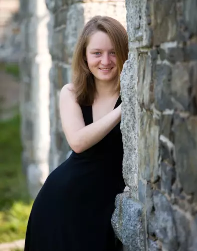 senior girl photographed at stone wall of ruin building in maine