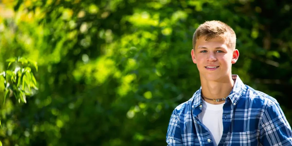boy in plaid shirt from cumberland's greely high school senior photos at park in maine