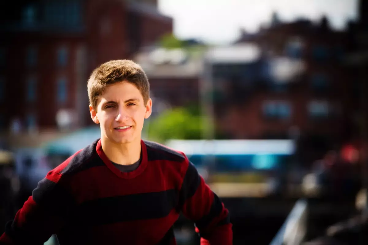 boy in red and navy sweater photographed downtown portland maine for senior pictures