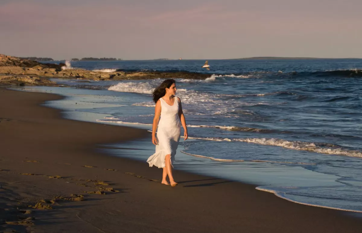 brunswick high school girl walking in sand at professional senior photos in maine at the beach