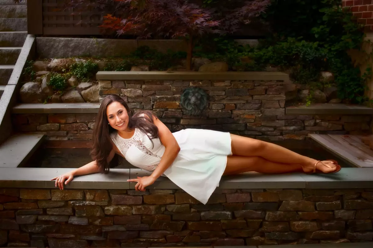 cheverus high school senior picture of girl laying on wall in back yard at portland maine home