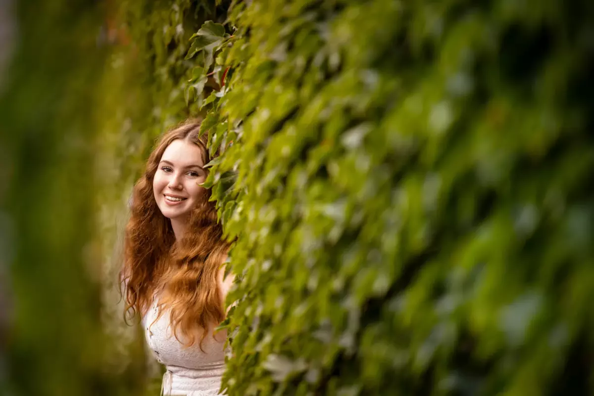 falmouth high school girl photographed in downtown portland maine with ivy walls for senior portrait