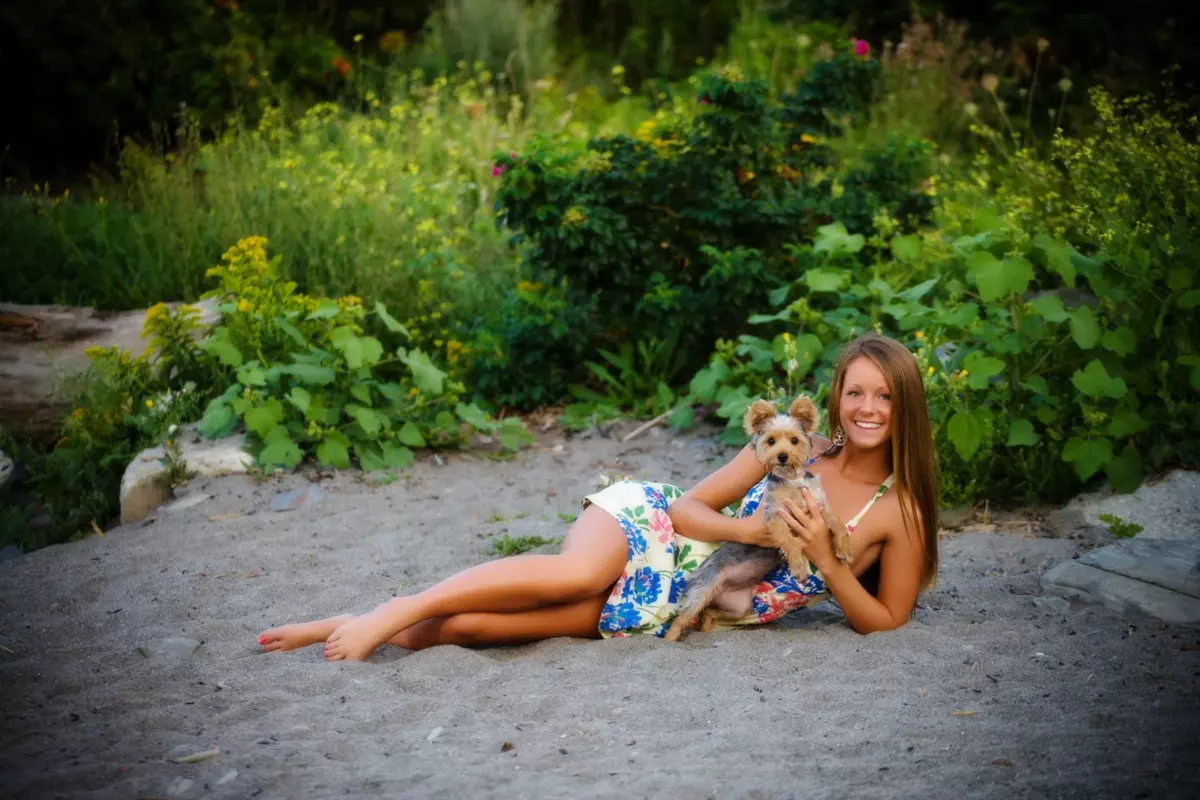 girl holding dog at senior pictures at the beach in maine
