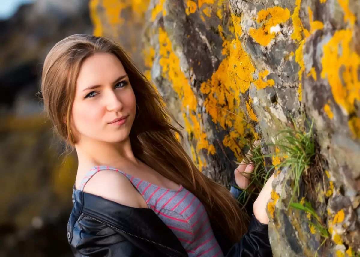 girl in leather jacket at stone wall beach in maine for senior portrait photography