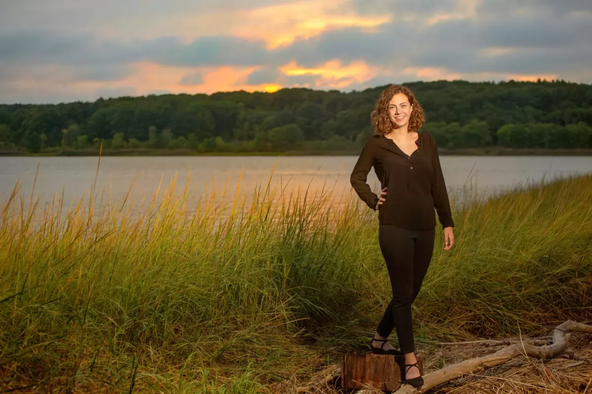 girl standing along river and wetland for senior photos at maine audubon center's gilsland farm in falmouth maine