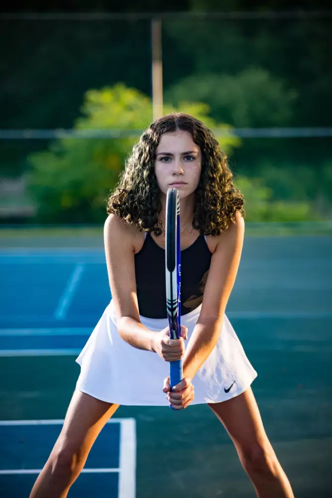 girl with tennis racquet at courts for senior pictures