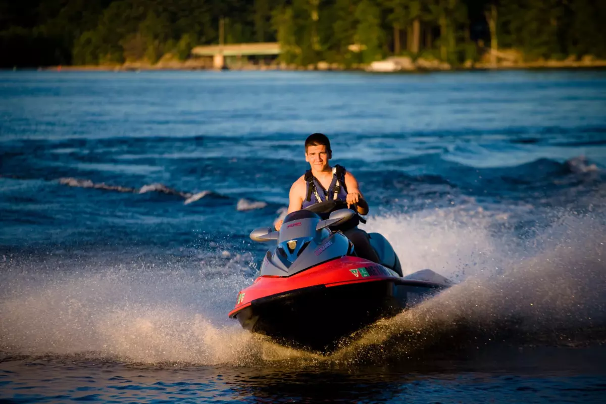 high school boy on jetski at lake sebago for maine senior pictures