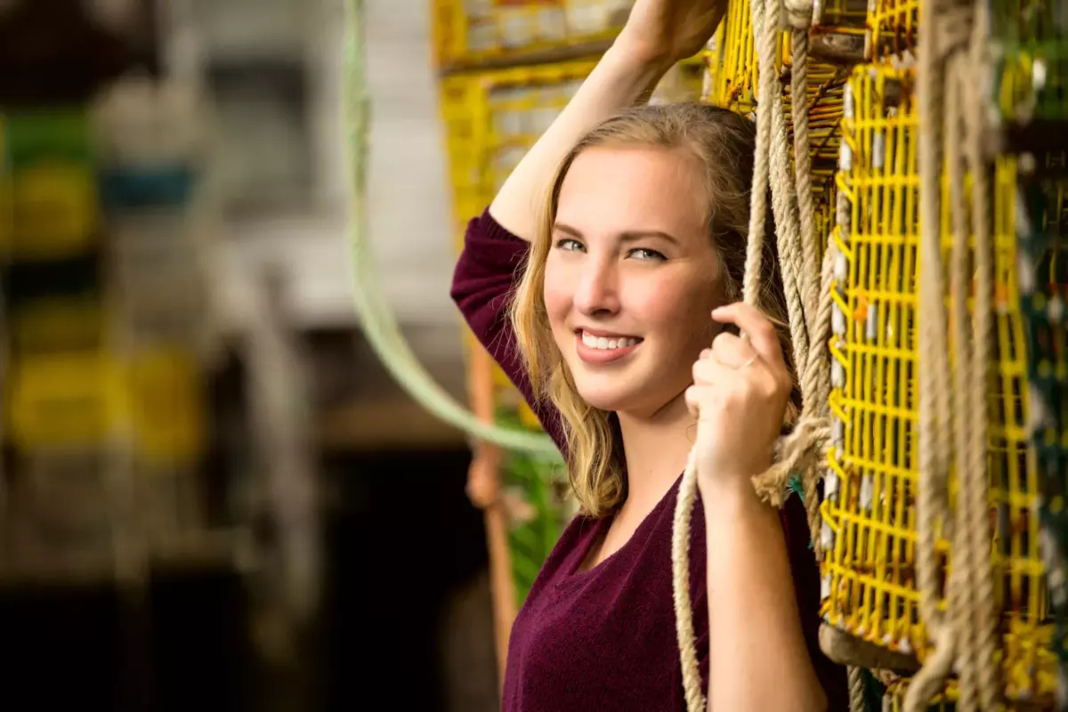 high school girl photographed against lobster traps in portland maine senior pictures photo shoot
