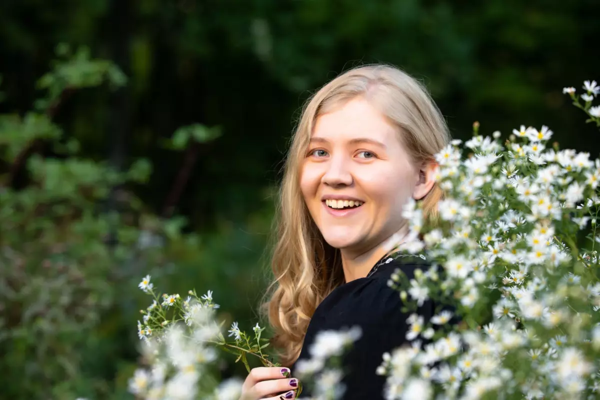 high school girl photographed at park with wildflowers for senior pictures