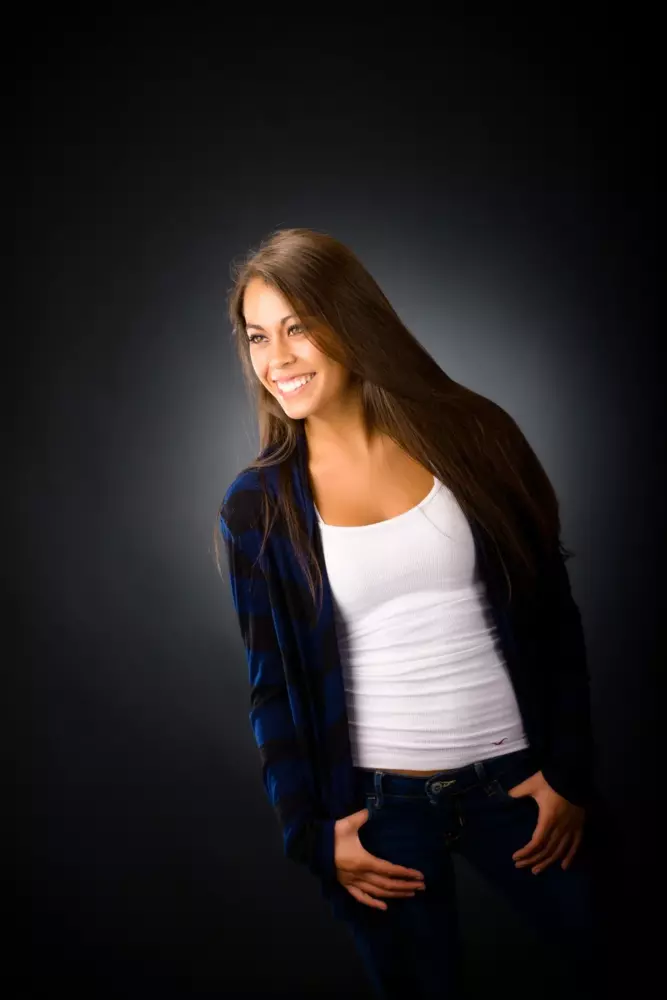 high school senior photo of girl in leather jacket and white shirt in professional photography studio in maine