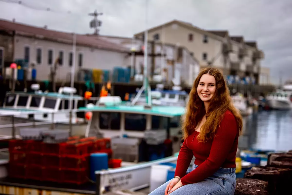 high school senior portrait of girl at downtown portland, maine's waterfront with fishing boats and lobster traps