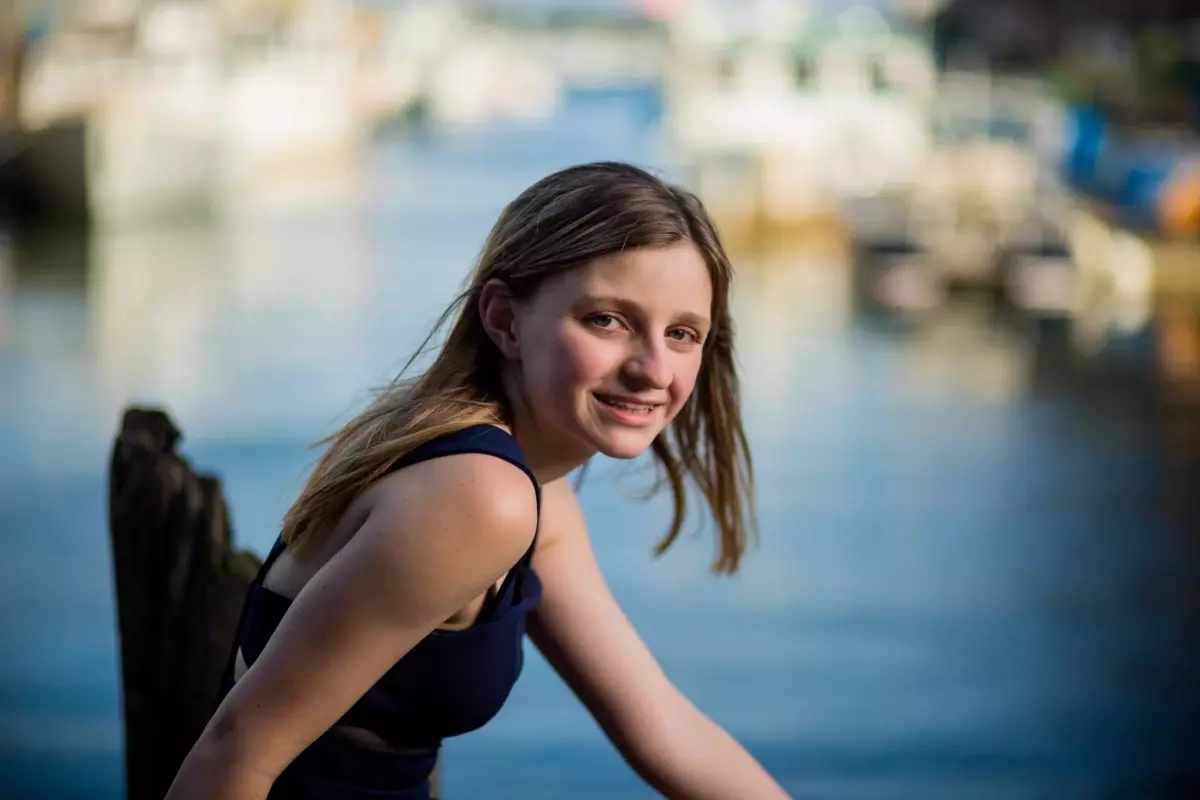 senior girl photographed at waterfront with ocean behind in portland, maine
