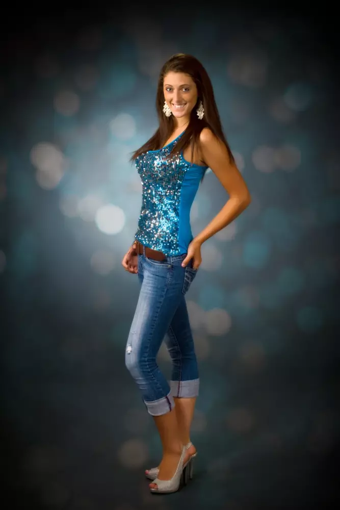 senior girl wearing sequined top photographed in professional photography studio in maine